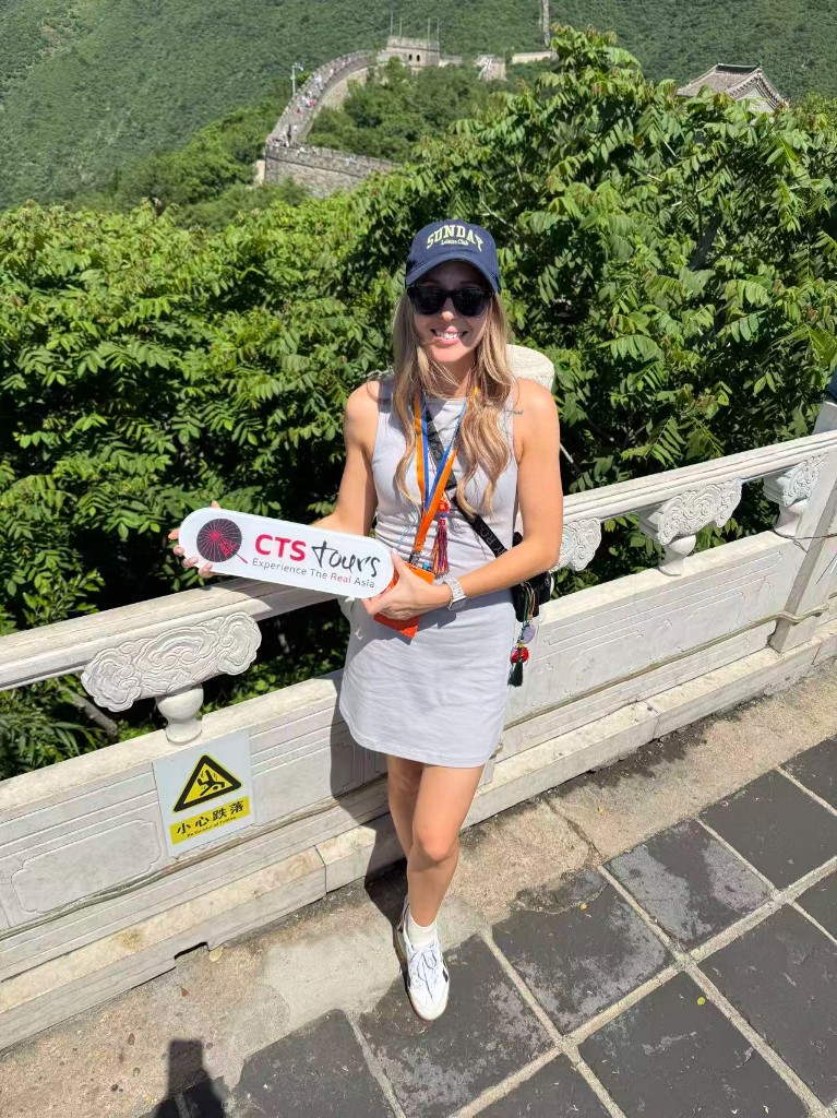 Asiascape staff member with CTS Tours signage at the Great Wall of China