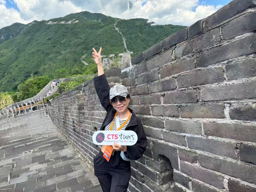 Asiascape staff member with CTS Tours signage at the Great Wall of China