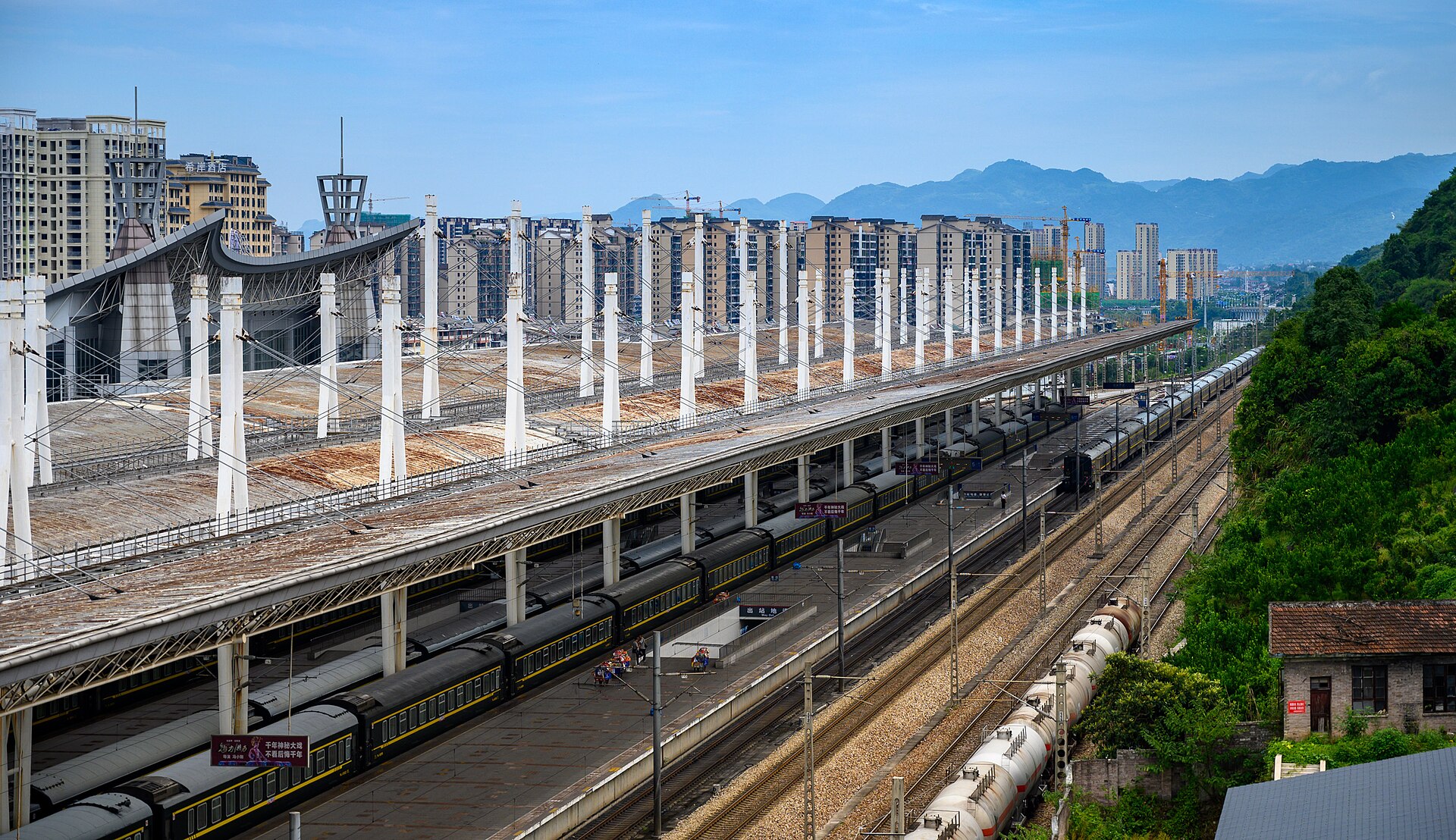 Railway platforms at Zhangjiajie station with mountains in the distance