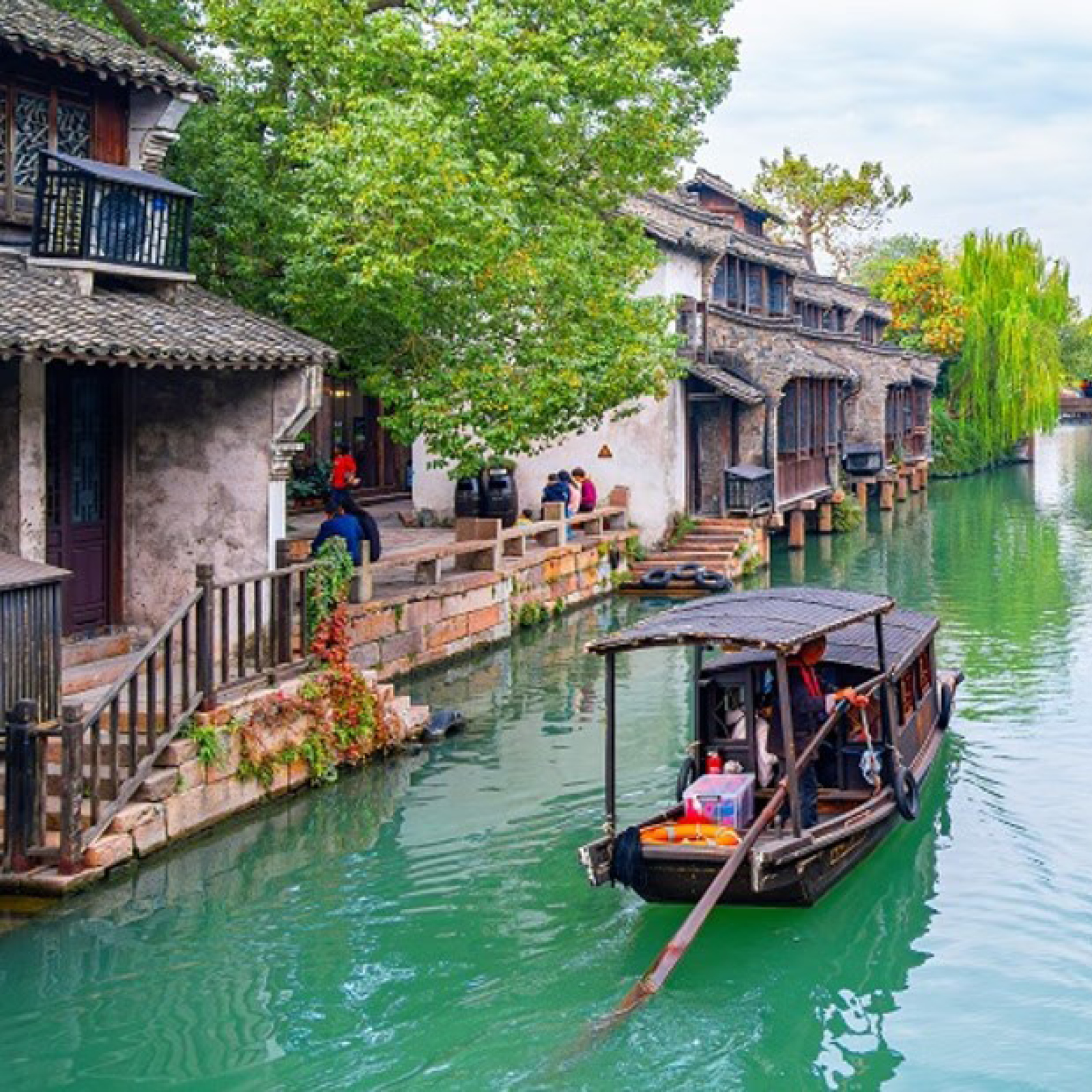 Classical canal scene in Suzhou — stone bridges and whitewashed Jiangnan buildings reflected in the water
